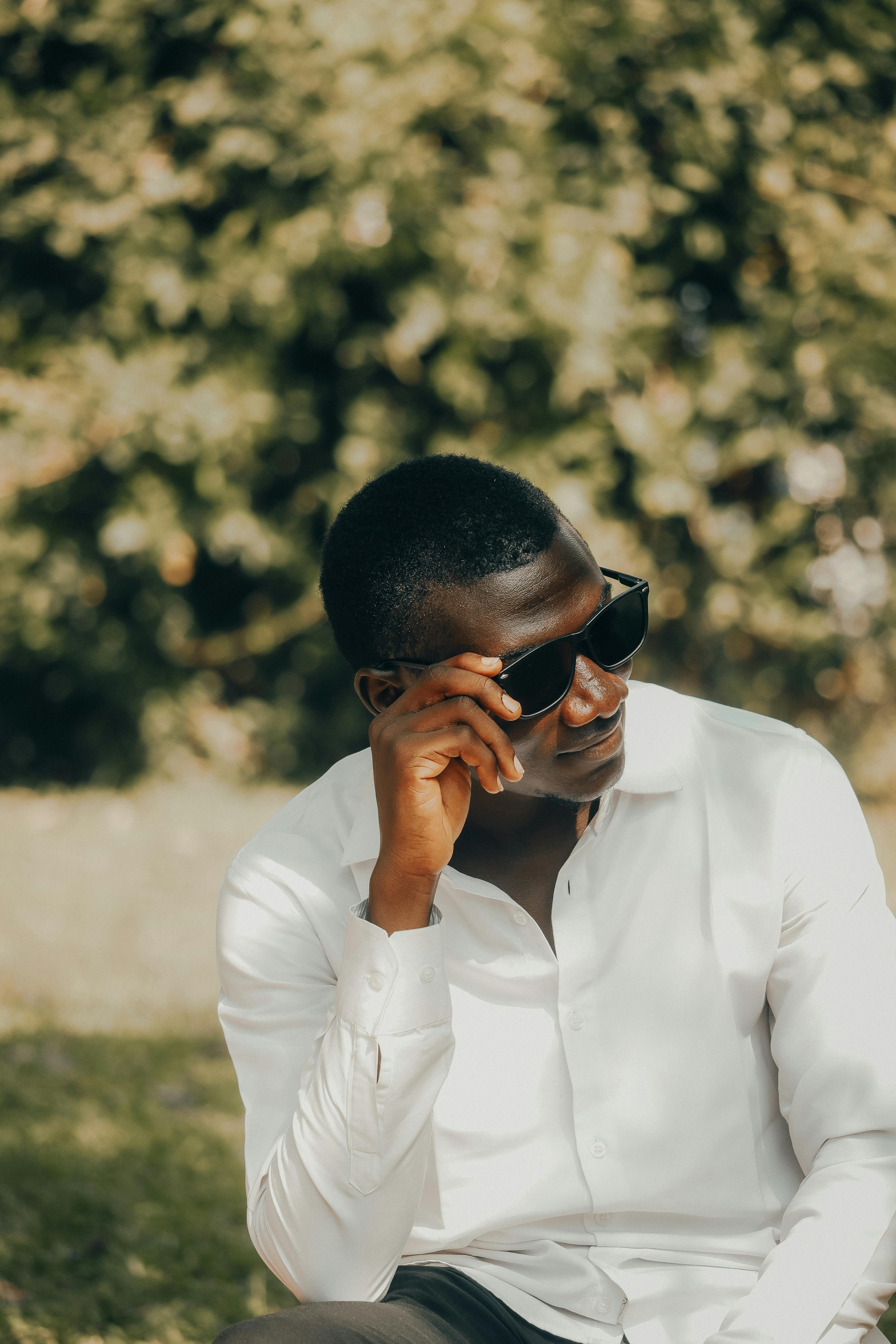 Stylish young man wearing sunglasses and white shirt enjoying the outdoors.