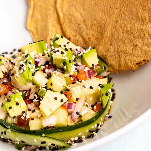 Free Delicious avocado cucumber salad with sesame seeds and tostadas, perfect for summer. Stock Photo