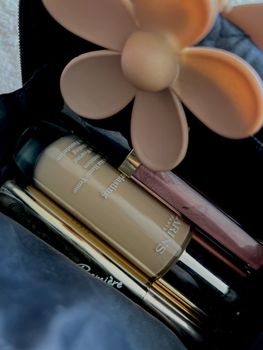 Stylish arrangement of beauty products with a floral touch, perfect for beauty enthusiasts.
