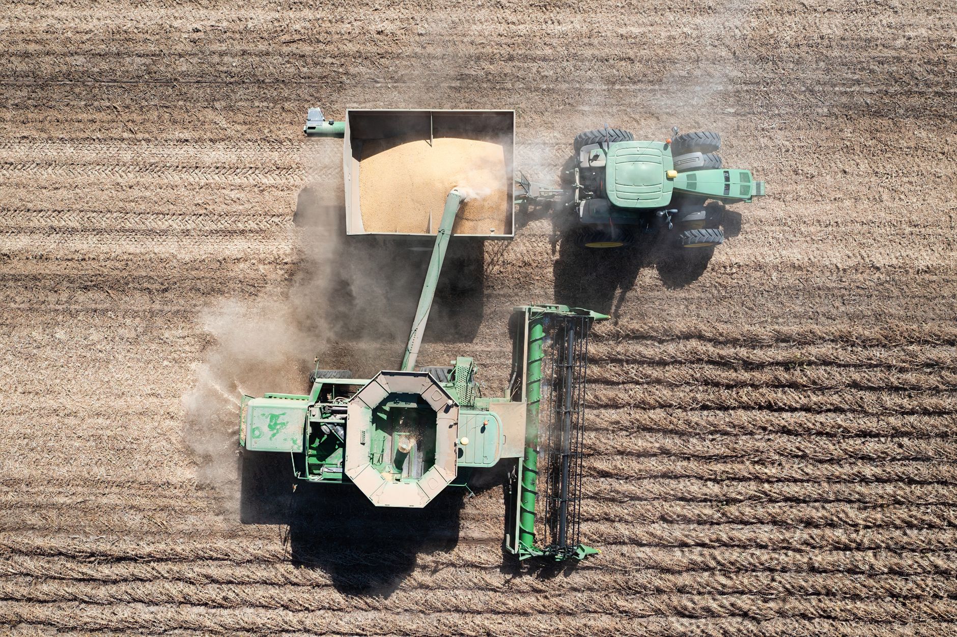 Overhead shot of a green combine harvester working in a Minnesota wheat field.