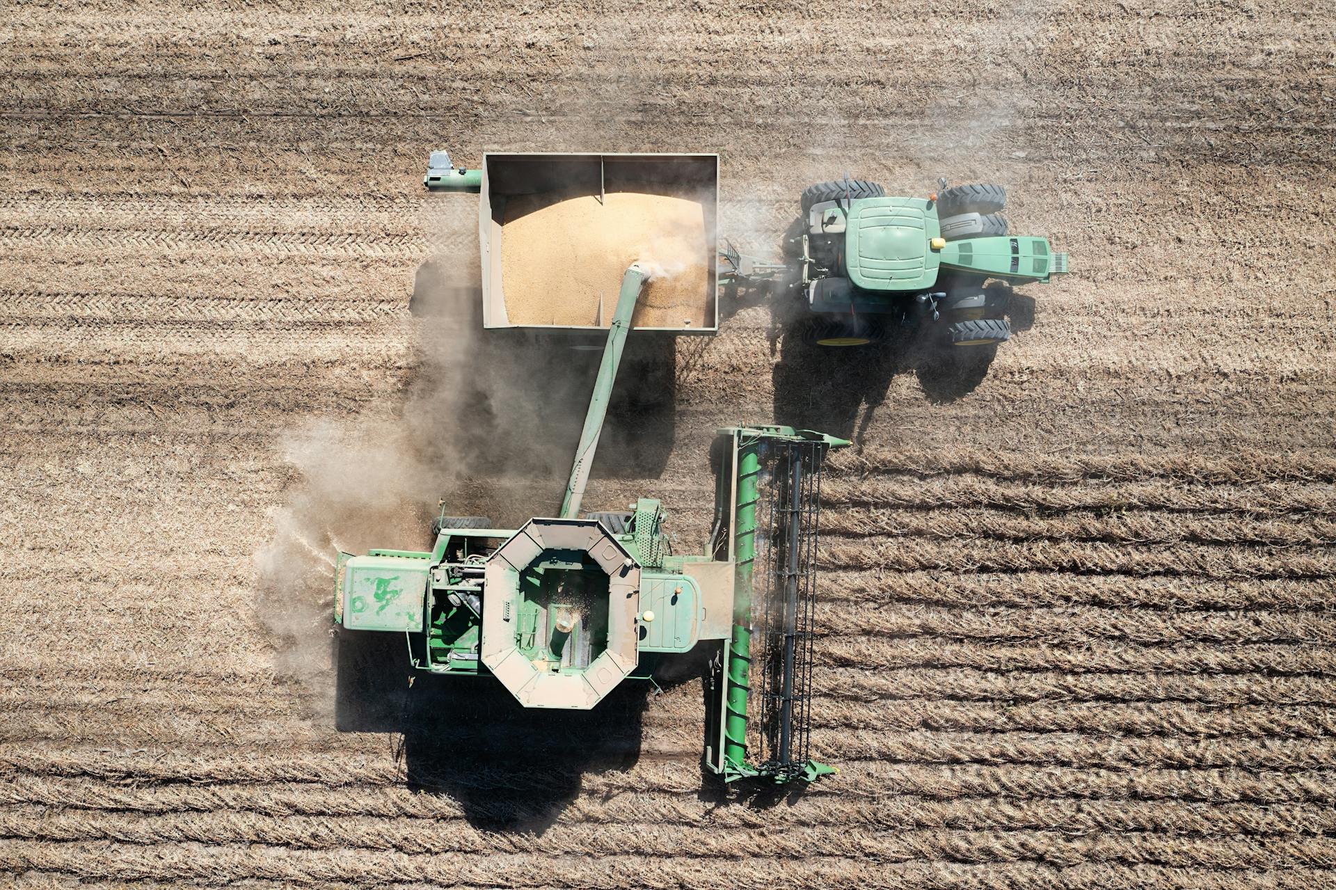 Overhead shot of a green combine harvester working in a Minnesota wheat field.