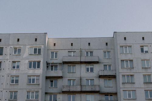 Free A concrete apartment building under a clear blue sky, showcasing urban architecture. Stock Photo