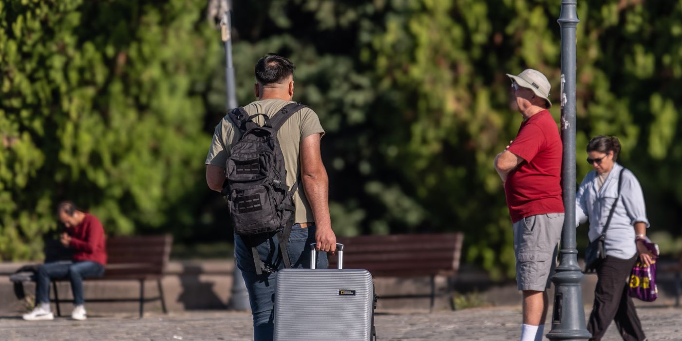 A traveler with a suitcase in a city, ready to switch between two hotels in one trip in 2026