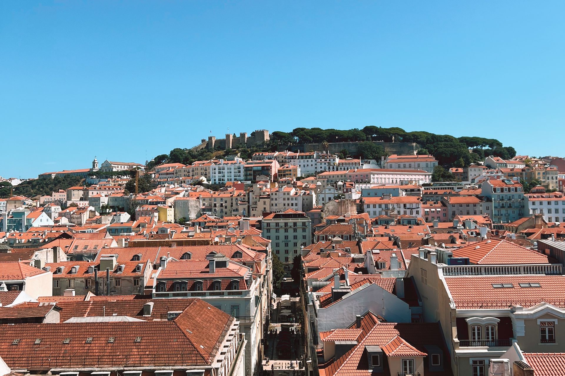 Panoramic view of Lisbon's colorful Alfama district with the Tagus River in the background