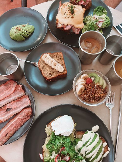 Free A vibrant brunch spread featuring avocado toast, banana bread, and fresh greens. Stock Photo