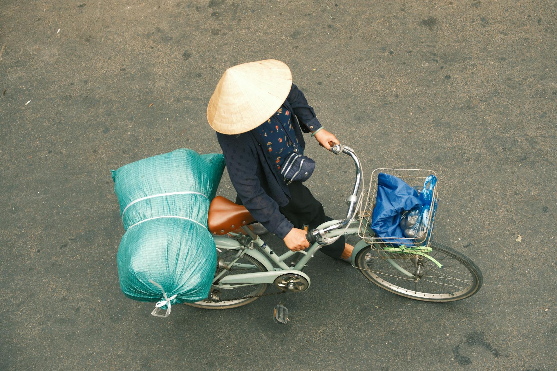 A person rides a bicycle with cargo through the streets of Hanoi, Vietnam.