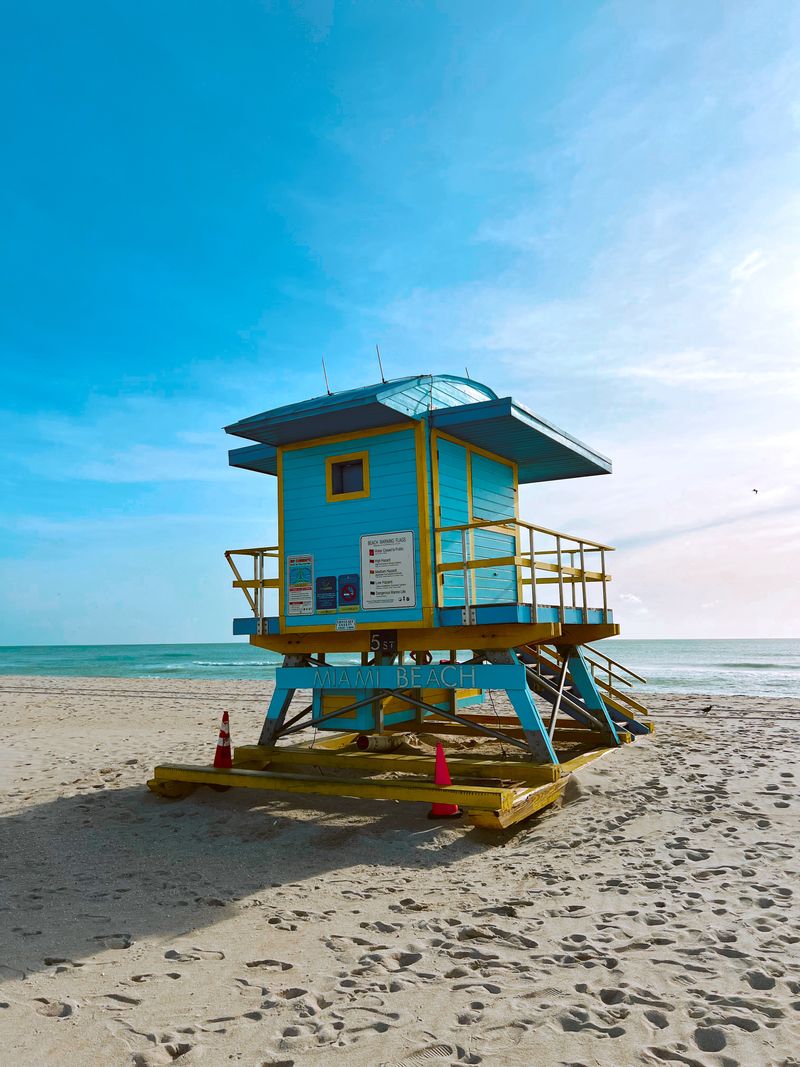 A turquoise lifeguard tower on the white sand of Miami Beach