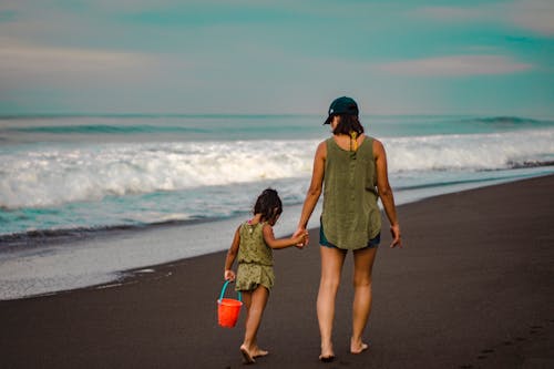 Vista Posteriore Foto Di Donna E Bambino Che Si Tengono Per Mano Mentre Si Cammina Sulla Spiaggia