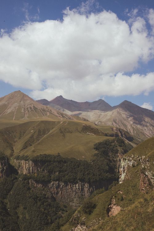 Free Scenic mountain range with clear blue skies and lush green valleys offering a serene natural view. Stock Photo