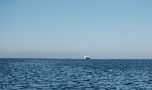 Free A serene scene of a ferry traversing the calm waters of İzmir Gulf under a clear blue sky. Stock Photo