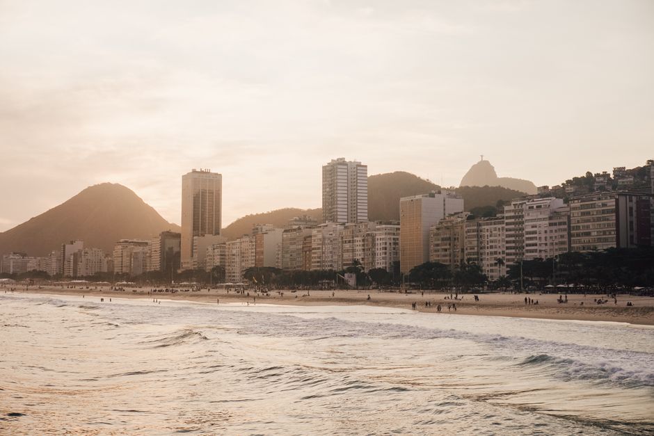 Beautiful sunset view of Copacabana Beach, Rio de Janeiro, showcasing cityscape and mountains.