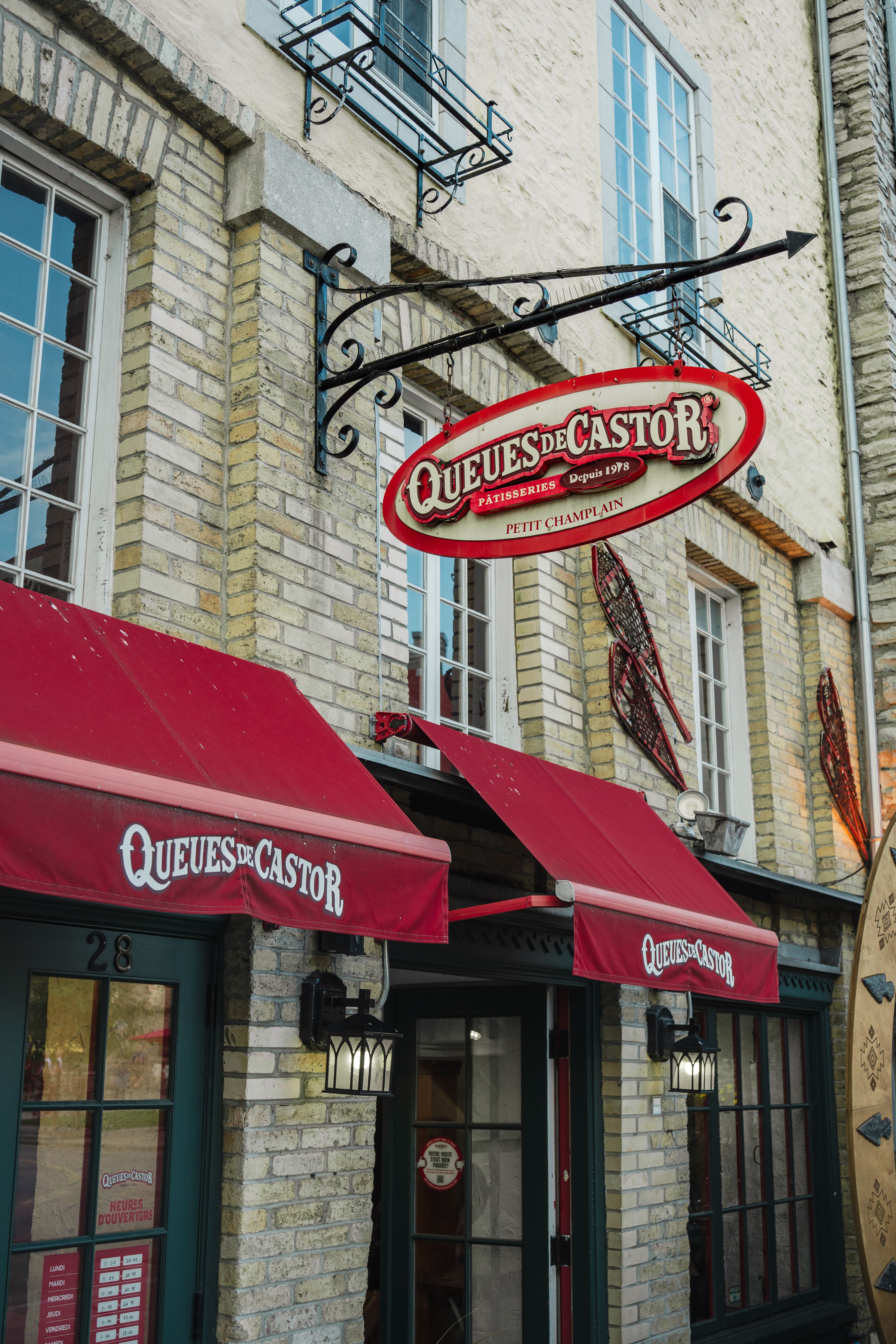 Charming exterior of BeaverTails pastry shop with red awnings in Quebec City.