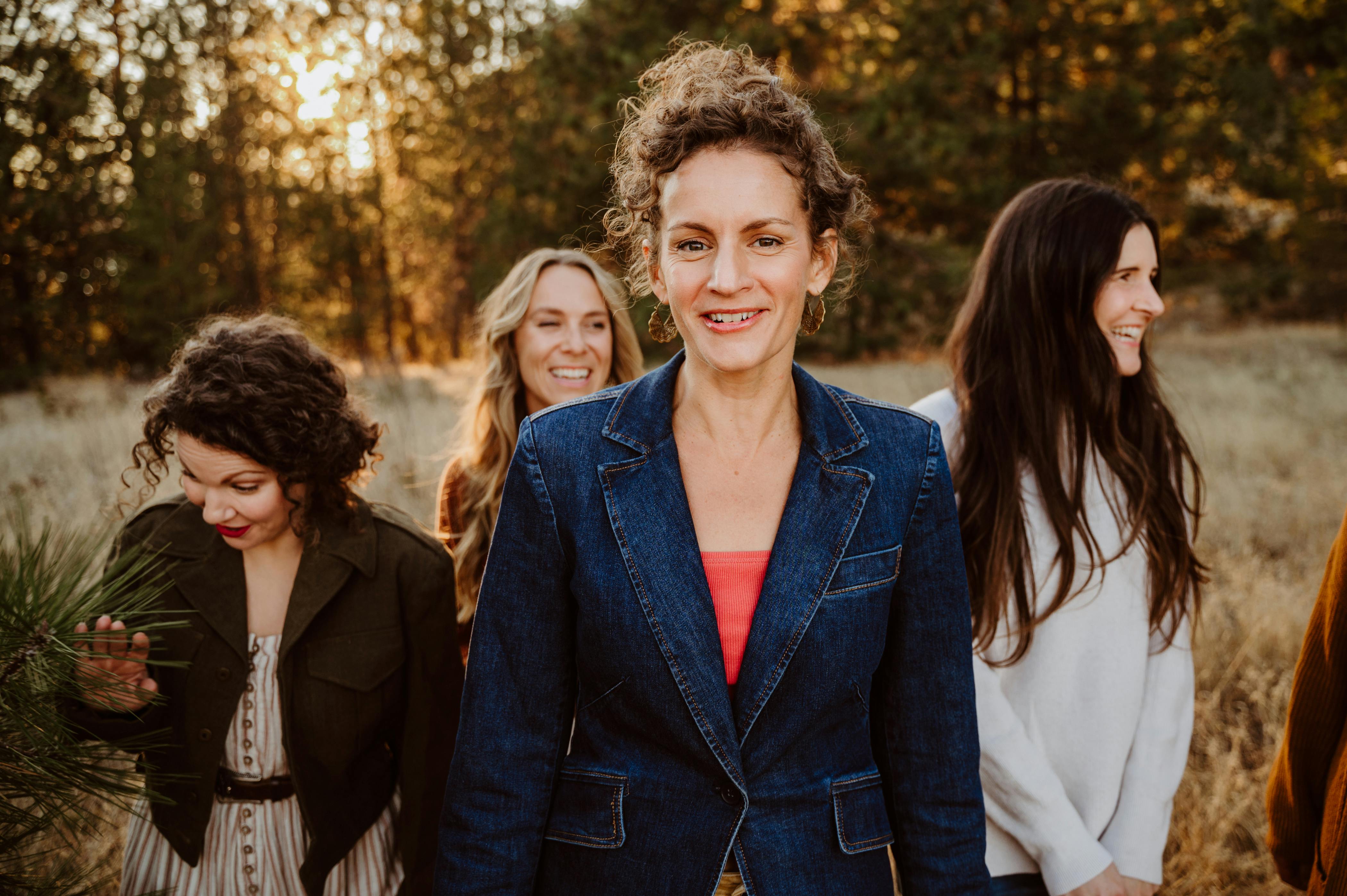 Women walking together and laughing at sunset in a park outdoors