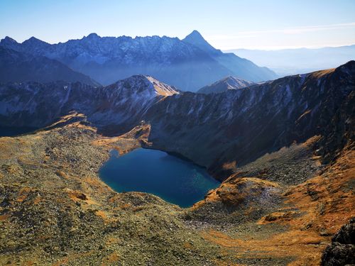 Free Aerial view of a serene mountain lake surrounded by rugged peaks, capturing the beauty of autumn. Stock Photo