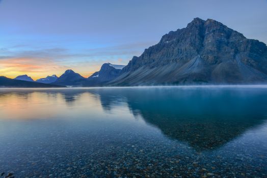 A breathtaking sunrise over Bow Lake with mountain reflections in Banff National Park, Alberta, Canada.