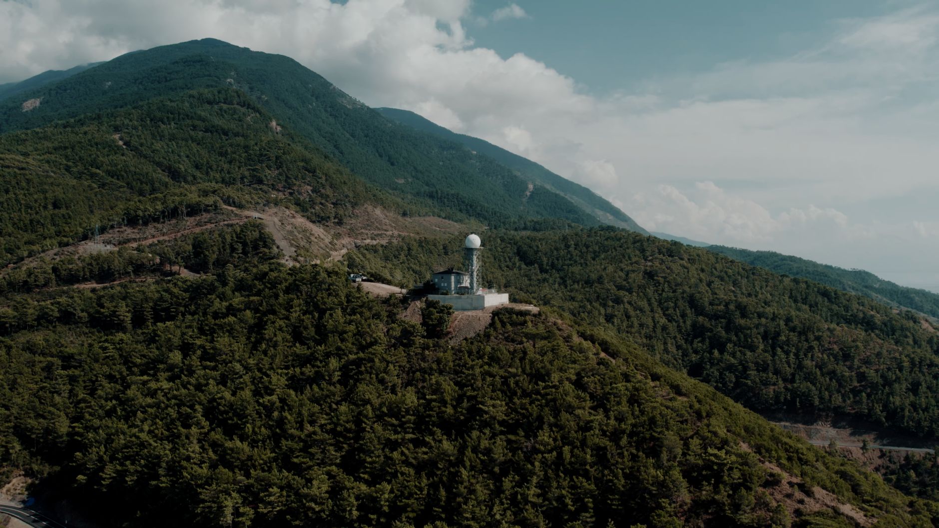 Stunning aerial shot of a radar station situated among lush mountainous terrain in Hatay, Türkiye.