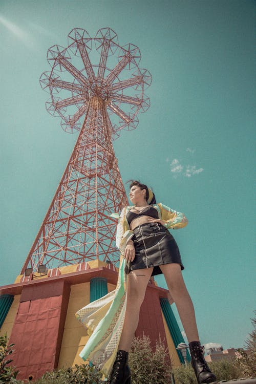 Низкоугловая фотография женщины, стоящей под башней