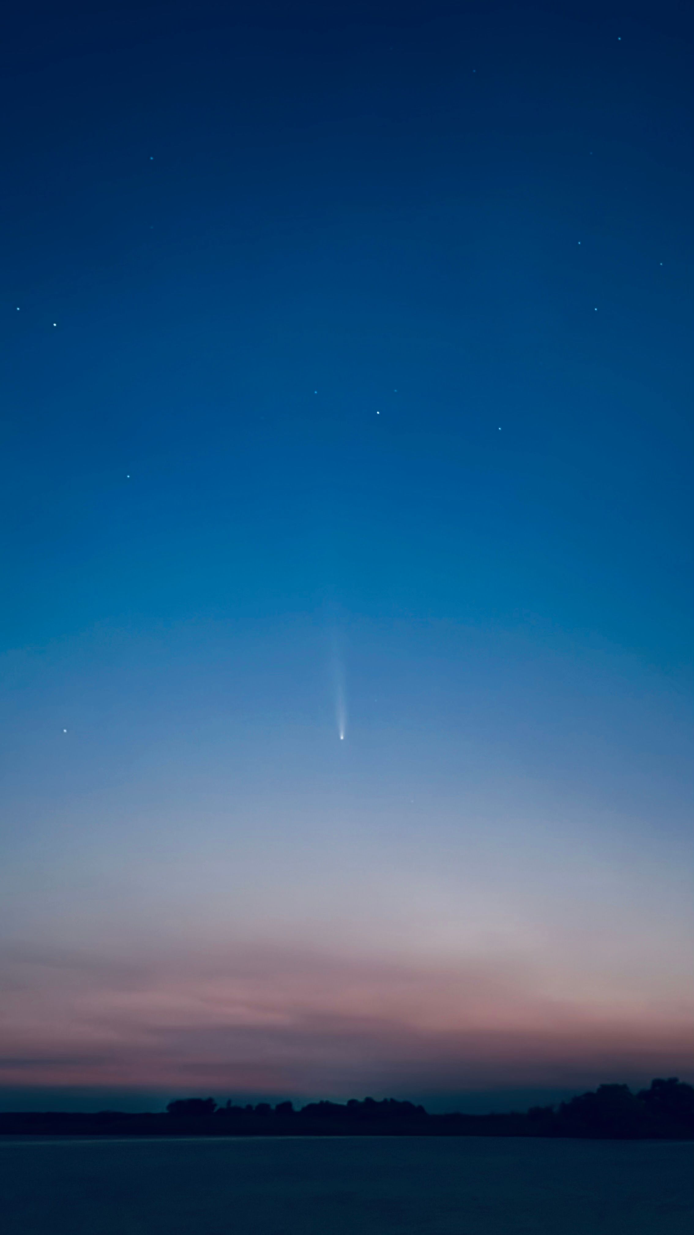 Fotomural Un hermoso cielo nocturno con un cometa visible rodeado de estrellas brillantes.