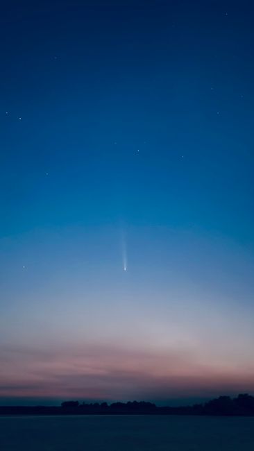 Fotomural Un hermoso cielo nocturno con un cometa visible rodeado de estrellas brillantes.