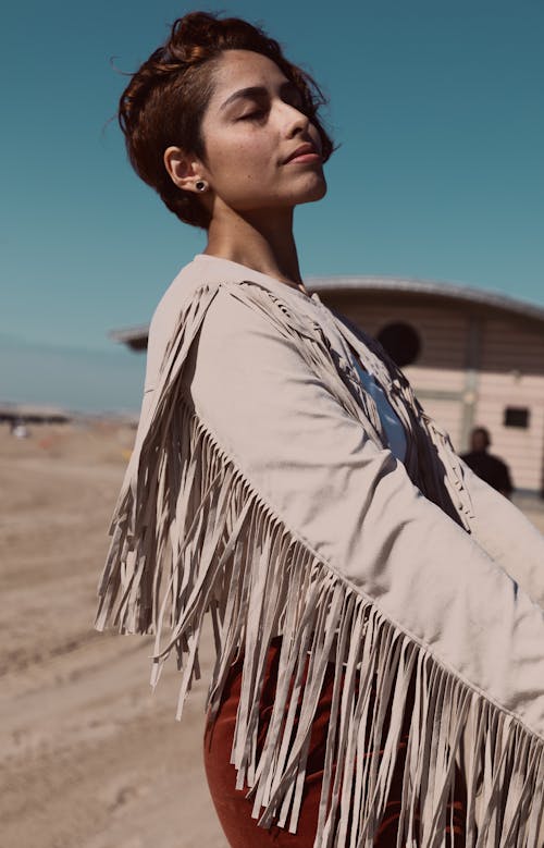 Selective Focus Side View Photo of Woman Wearing Beige Long-sleeved Shirt With Fringe Posing With Her Eyes Closed