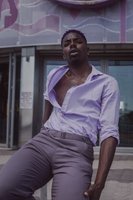 Elegant and expressive portrait of a fashionable adult male model posing confidently outdoors in New York City.