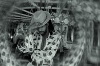 一位戴着帽子的时尚男子在纽约的老式旋转木马前摆姿势