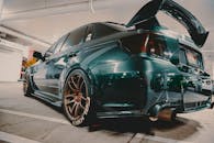 一辆配备定制钢圈和扰流器的现代跑车停在室内，尽显奢华与设计感