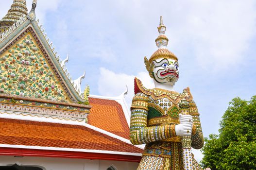 Colorful giant statue at a Buddhist temple in Thailand under a bright sky. Majestic architectural details.