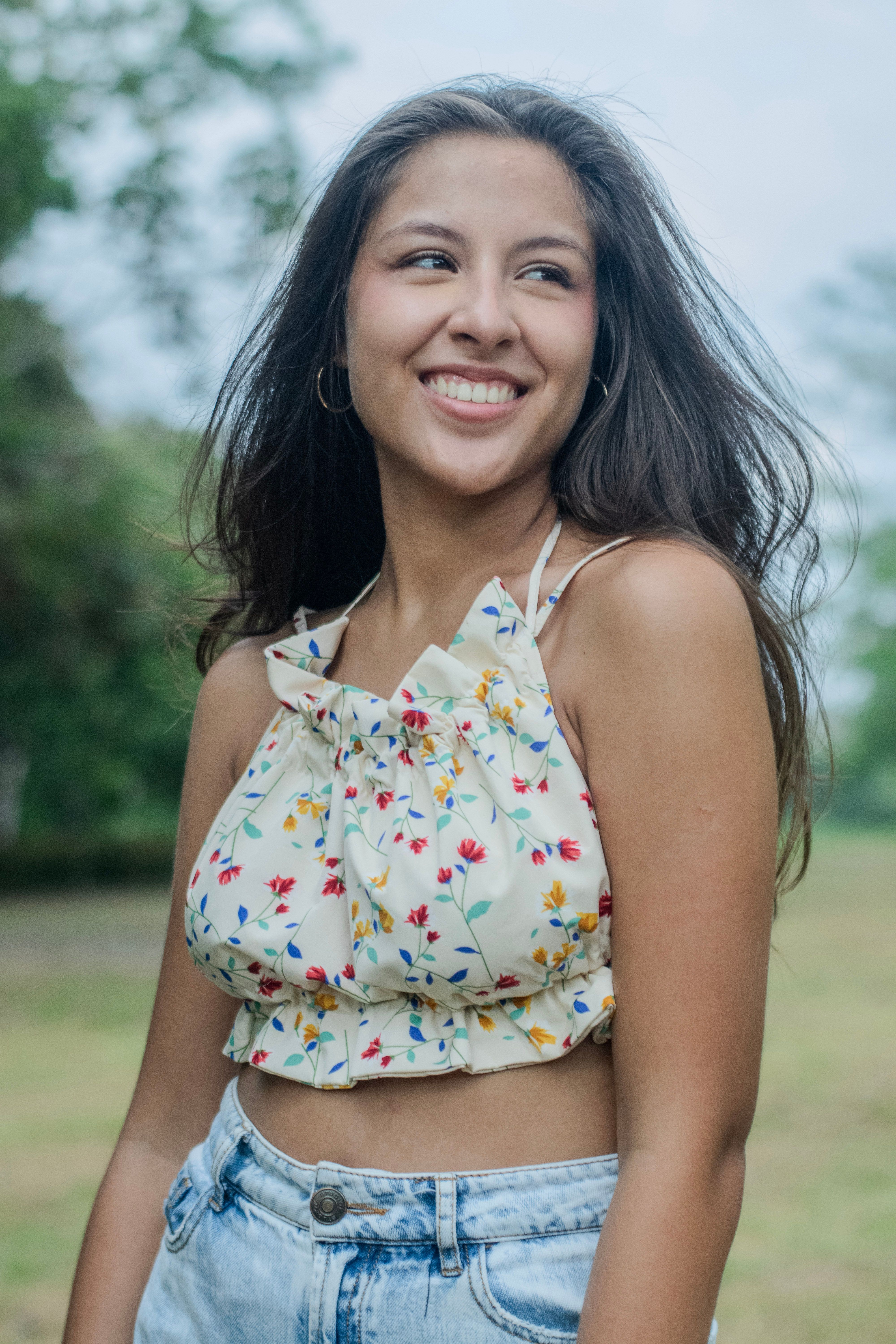 Smiling Woman in Floral Top Outdoors · Free Stock Photo