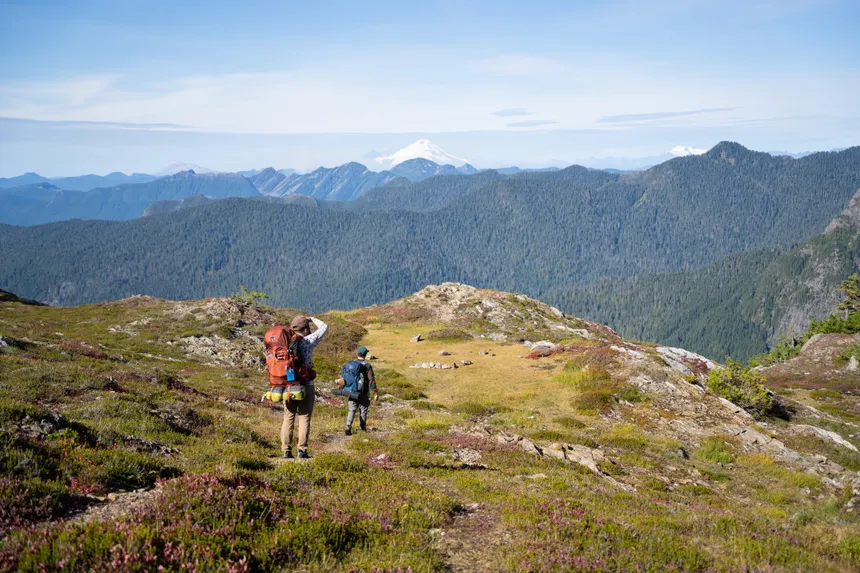 Hikers explore a scenic trail in the mountains near Darrington, Washington, offering breathtaking views.