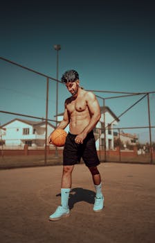 Shirtless athletic man holding a basketball on an outdoor court in Istanbul, Turkey.