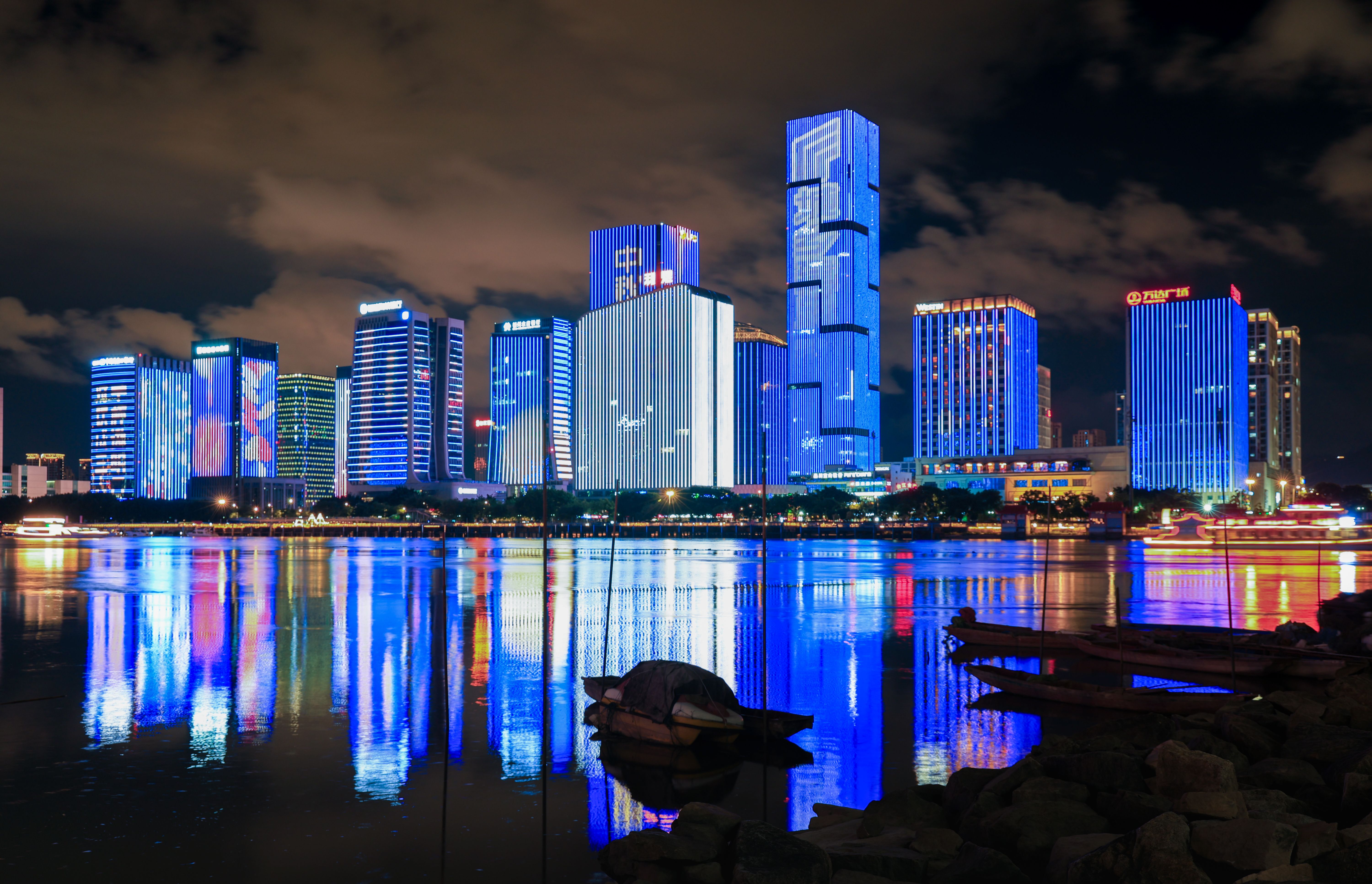 Vibrant City Skyline Reflecting in Water at Night · Free Stock Photo