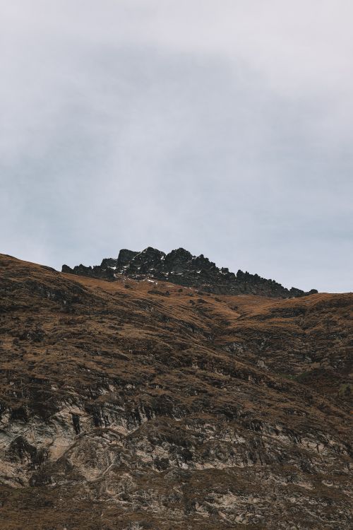 Free Explore the rugged beauty of a mountain peak near Queenstown, New Zealand, captured in autumn hues. Stock Photo