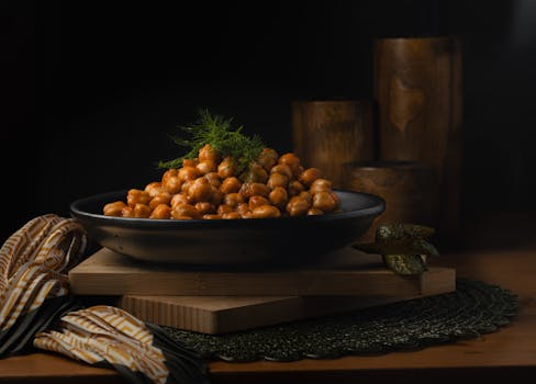 A beautifully presented plate of spicy chickpeas garnished with fresh herbs.