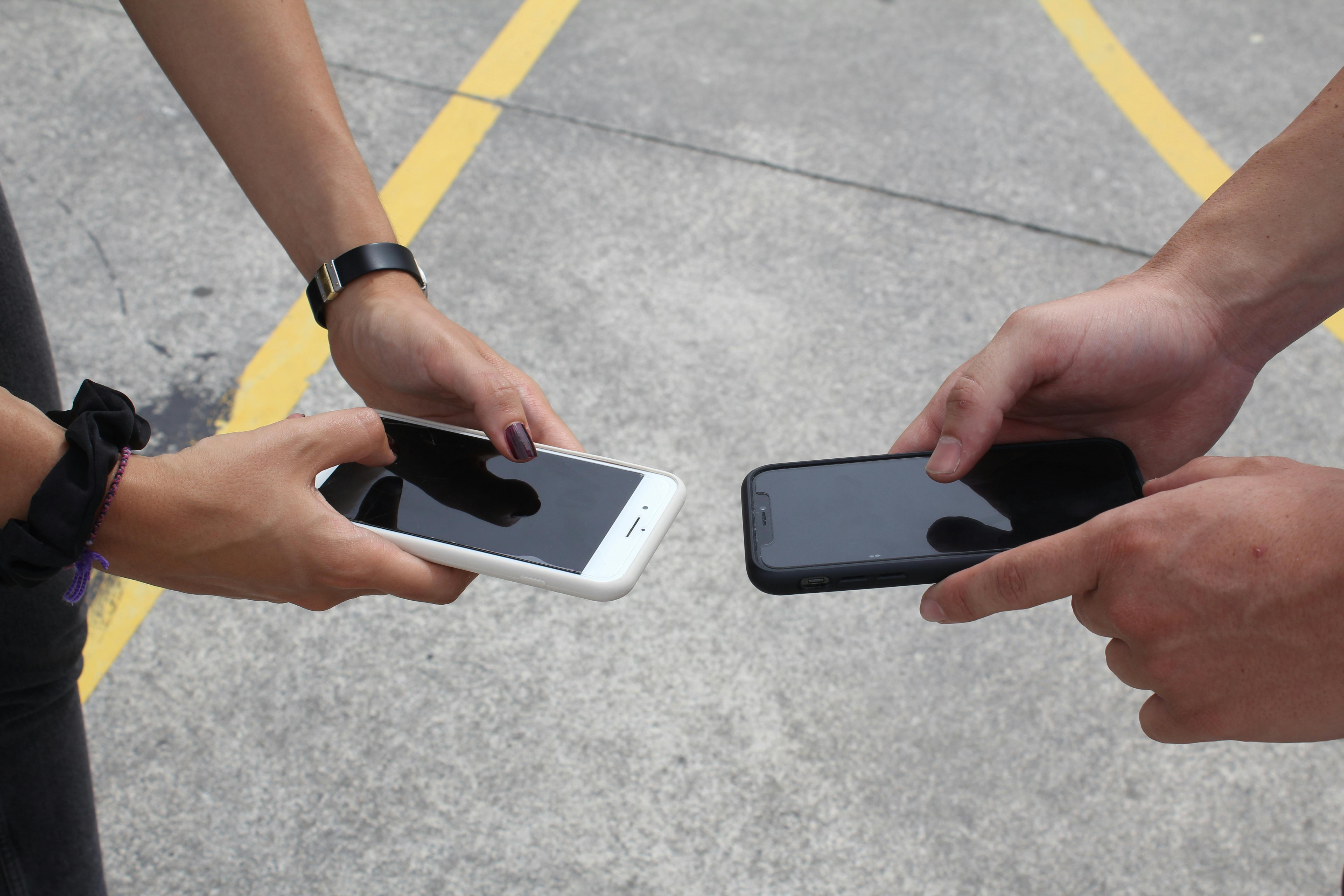Close-up of Hands Holding Smartphones Outdoors