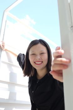 Cheerful woman in black shirt smiling outdoors on a sunny day.