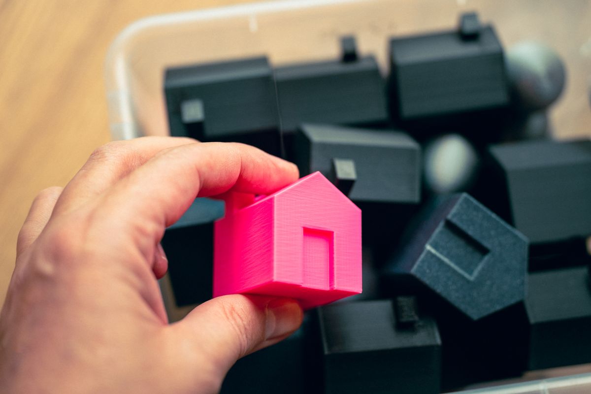 Hand placing a model block among others
