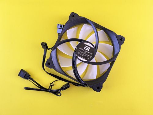 Free A black and white computer cooling fan with wiring on a bright yellow surface. Stock Photo