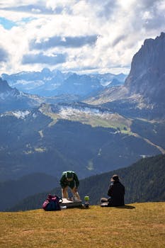 Two hikers enjoy a breathtaking mountain view in Trentino, South Tyrol, Italy.