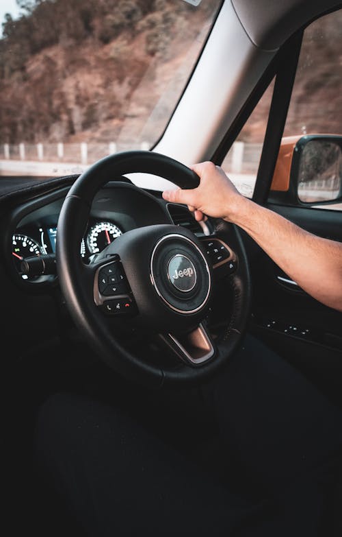 Free Person's Hand on Jeep Steering Wheel Stock Photo