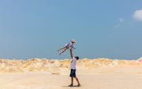 在阳光明媚的沙漠风景里，父亲和孩子共享欢乐时刻