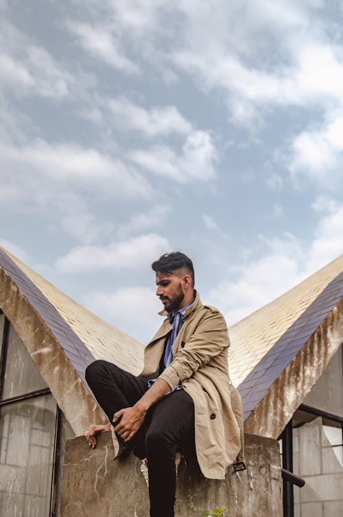 Man Sitting on Gray and Brown Roof Surface
