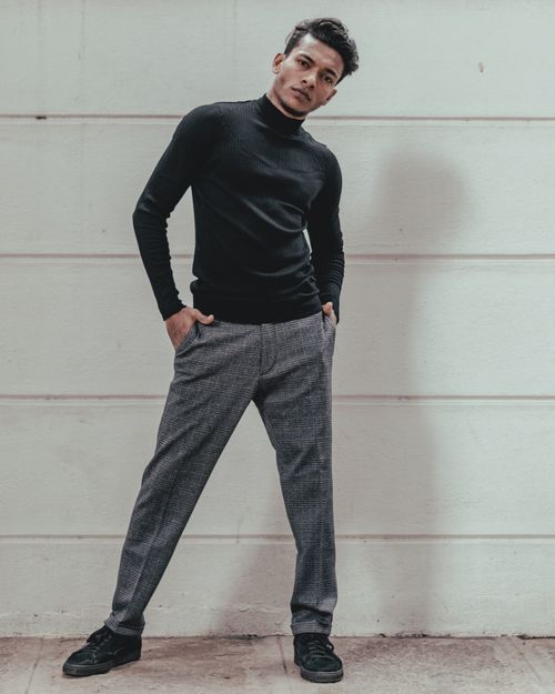 Free Confident adult male posing stylishly against a white urban wall. Stock Photo