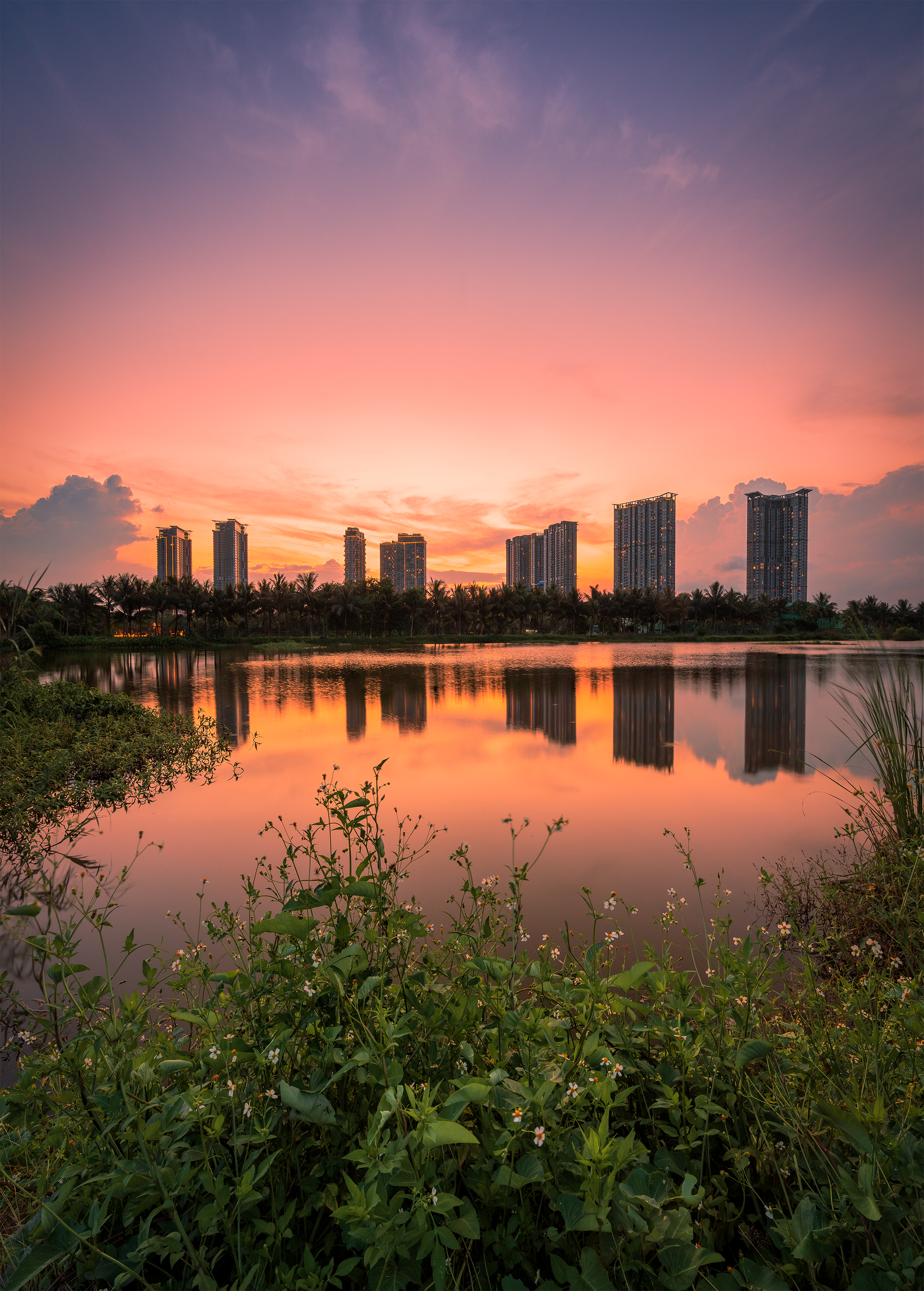 Vibrant Urban Sunset Reflected in Tranquil Lake · Free Stock Photo