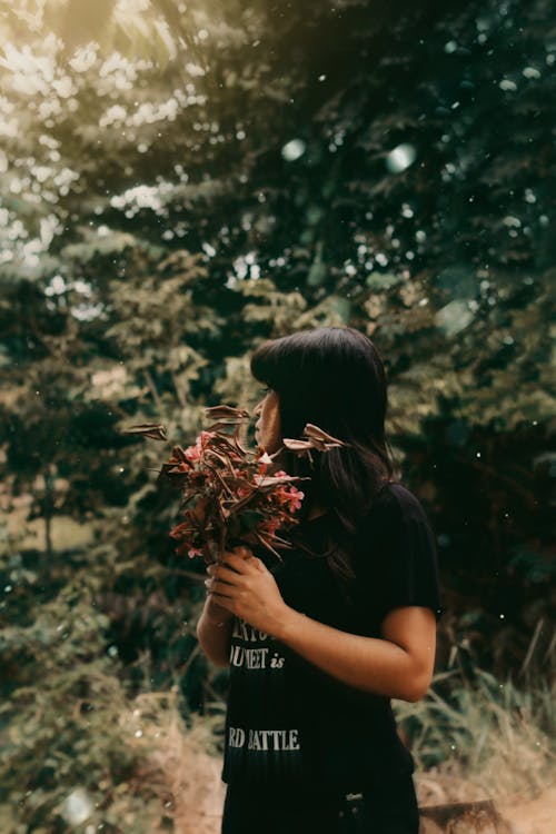 Woman Holding Green and Red-Leafed Flowers