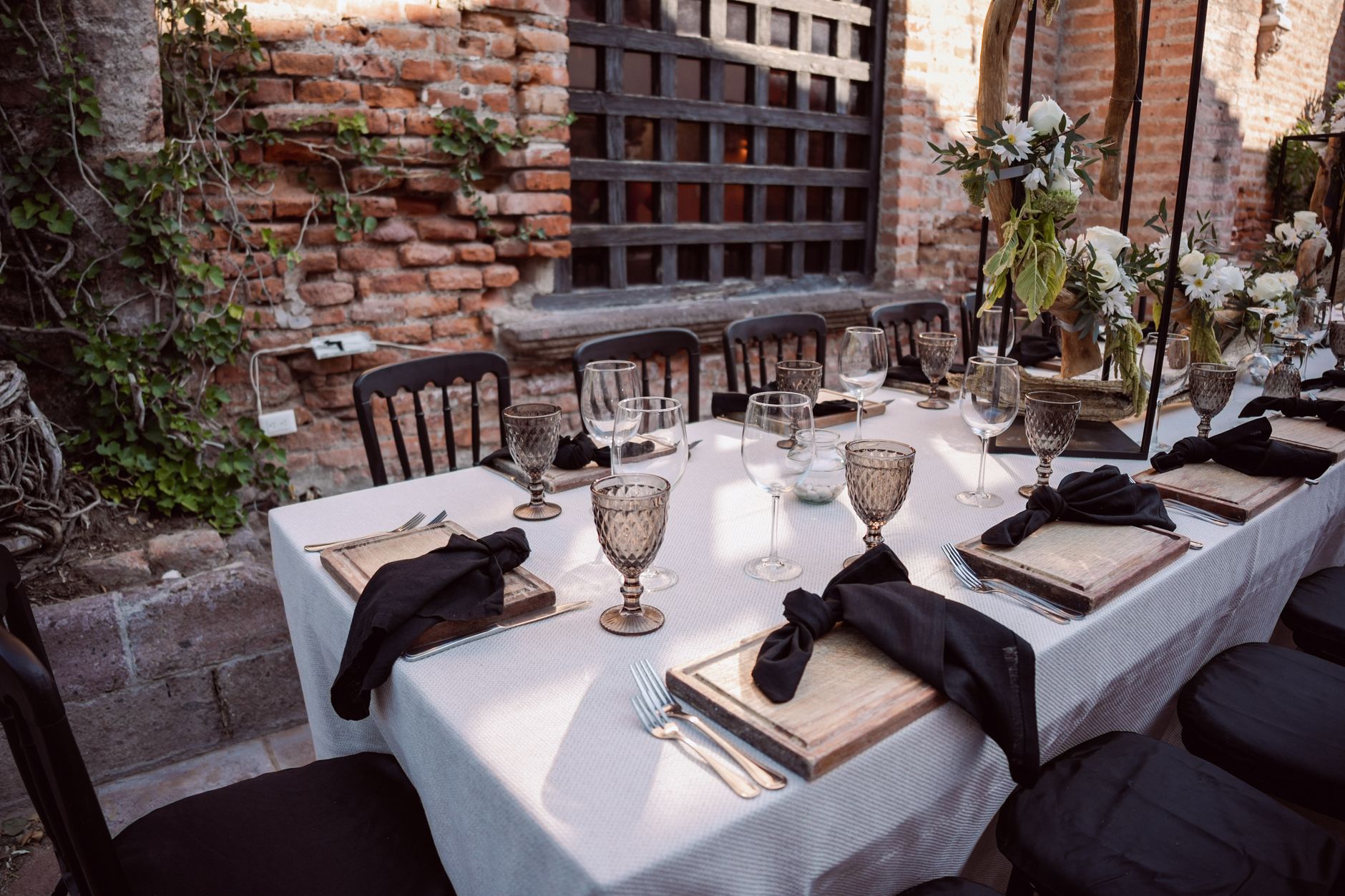 Beautifully arranged outdoor wedding table with floral decor and elegant tableware, ideal for a sophisticated event.