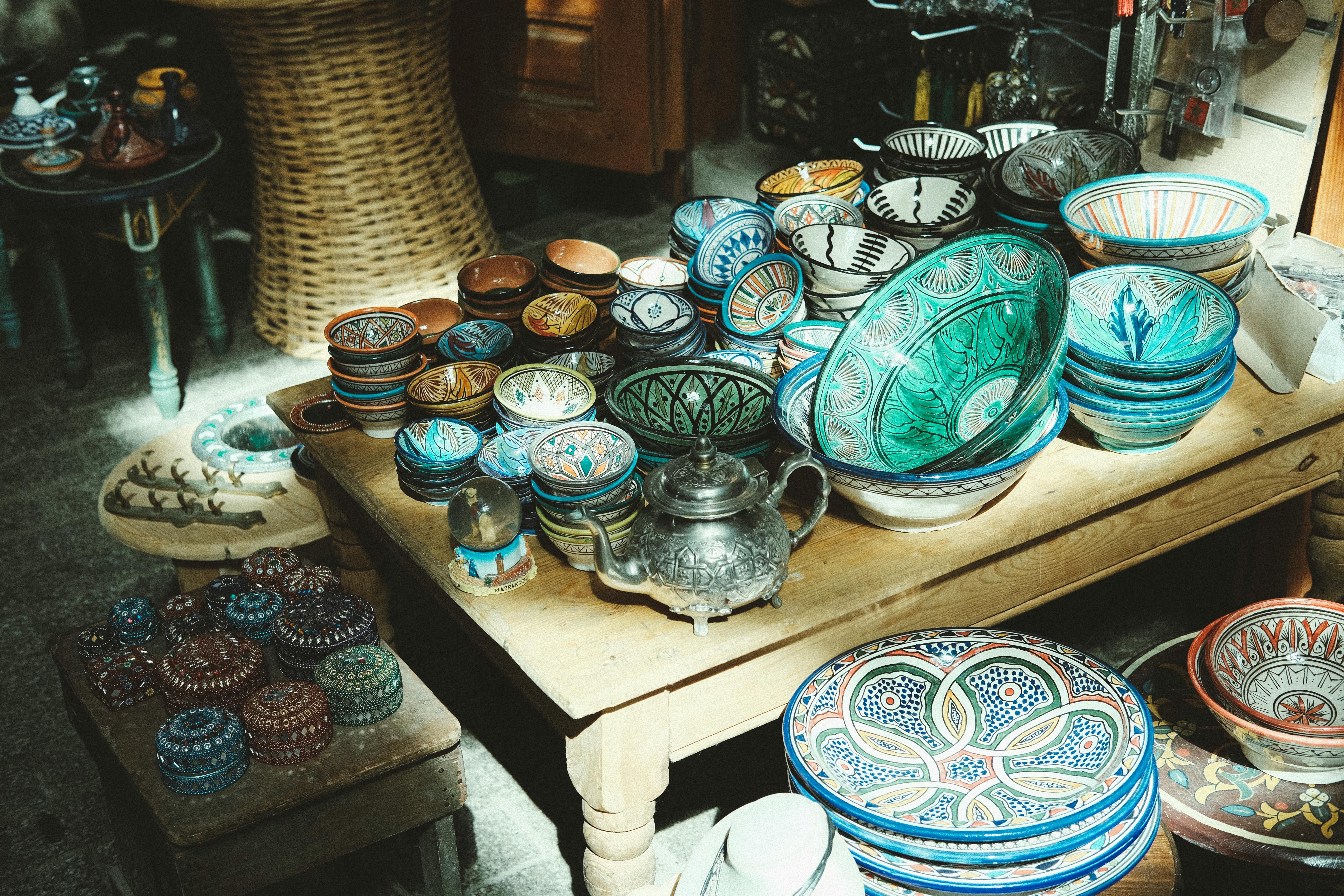 Vibrant Moroccan pottery and crafts displayed in natural light at an artisan market.