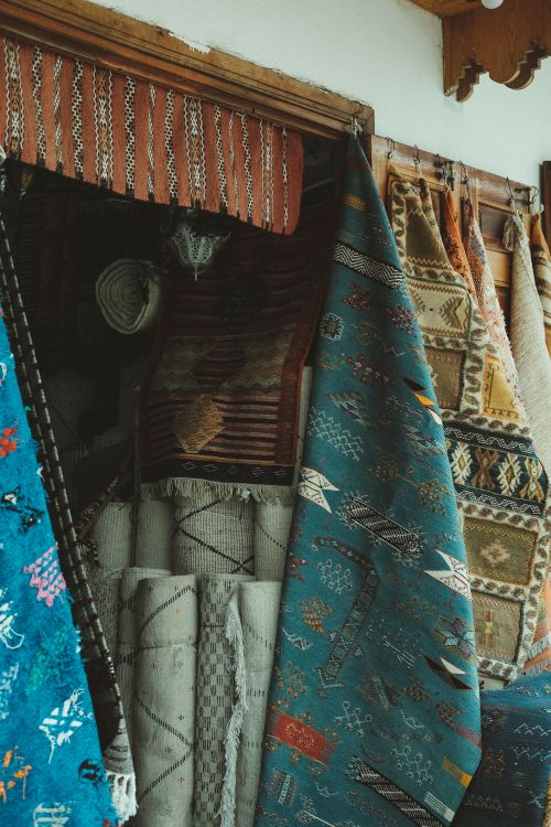 Free A vibrant display of traditional handwoven tapestries hanging in a market setting. Stock Photo