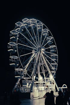 A glowing Ferris wheel lights up the night sky in Tirana, Albania.