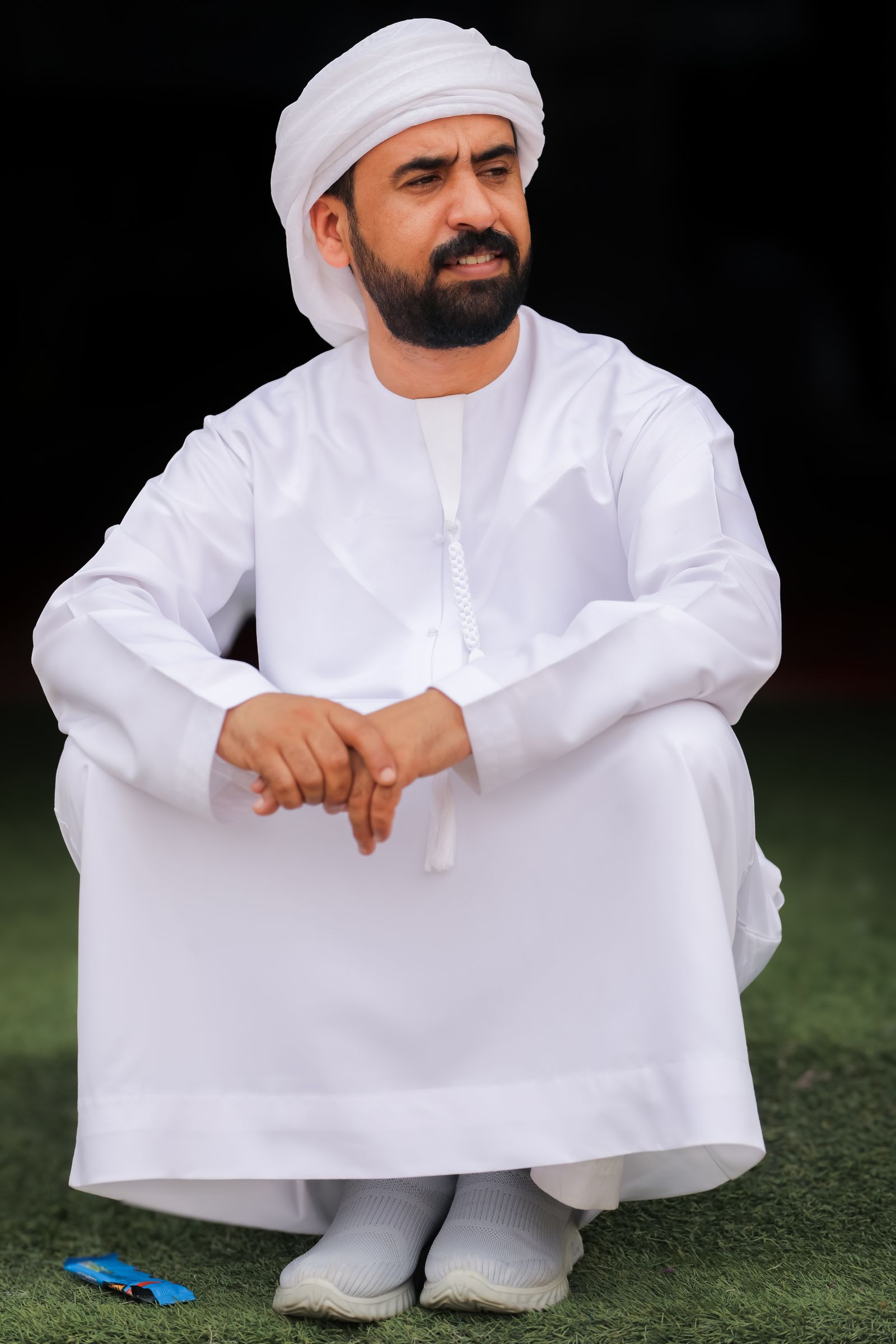 Man in traditional attire sitting outdoors